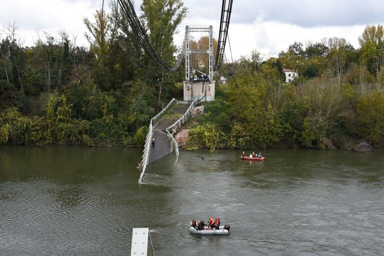 Rescuers sail near a suspension bridge which collapsed on November 18, 2019, in Mirepoix-sur-Tarn, near Toulouse, southwest France. – A 15-year-old girl was killed after a suspension bridge over a river collapsed on November 19, causing a car, a truck and possibly a third vehicle to plunge into the water, local authorities said. Four people were rescued but several others were feared missing after the collapse of the bridge linking the towns of Mirepoix-sur-Tarn and Bessieres, 30 kilometres (18 miles) north of the city of Toulouse, said fire service and local security chief Etienne Guyot. (Photo by ERIC CABANIS / AFP)