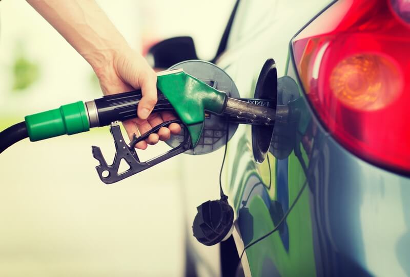 transportation and ownership concept – man pumping gasoline fuel in car at gas station