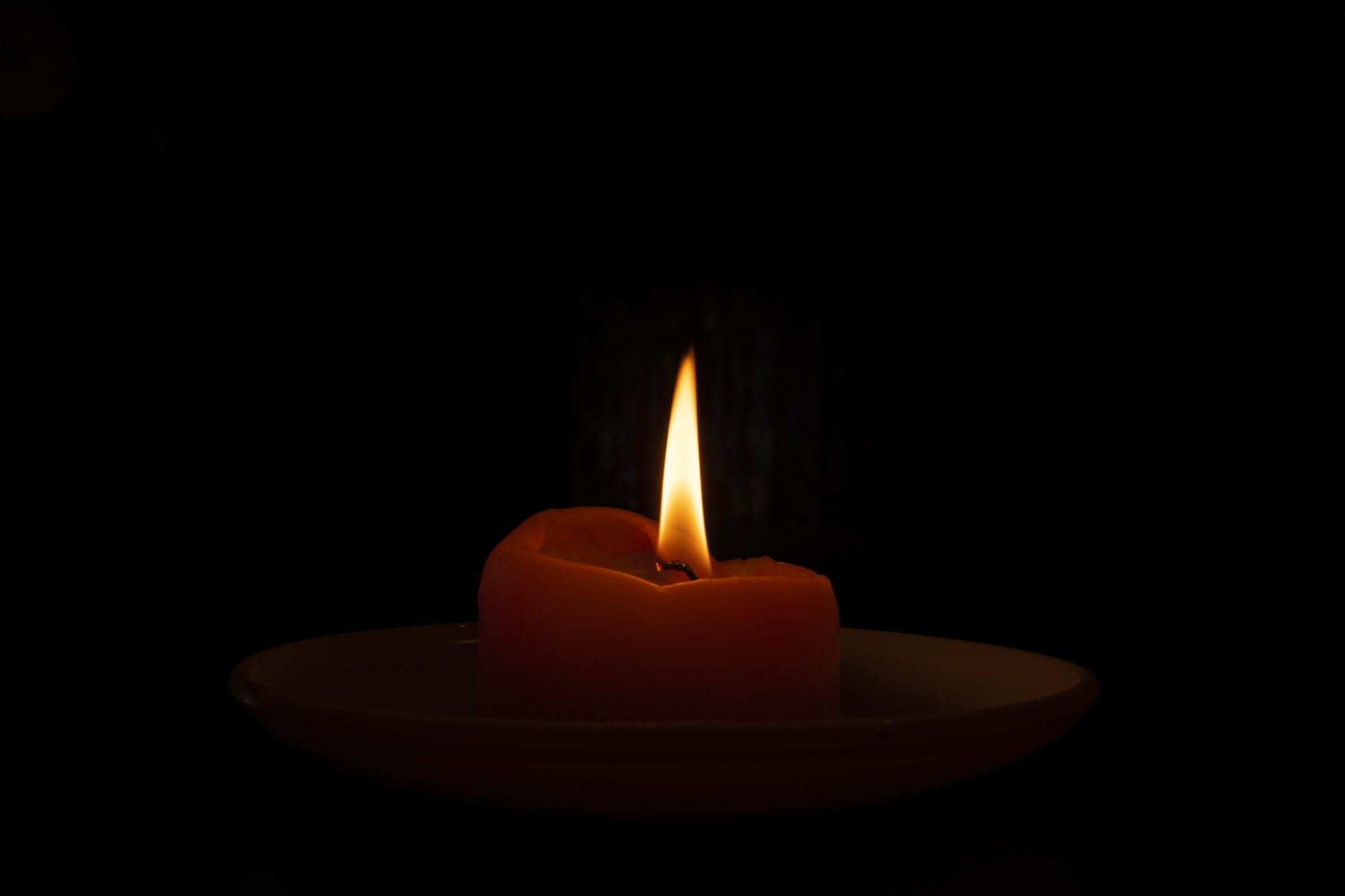 A closeup shot of a burning candle in the dark