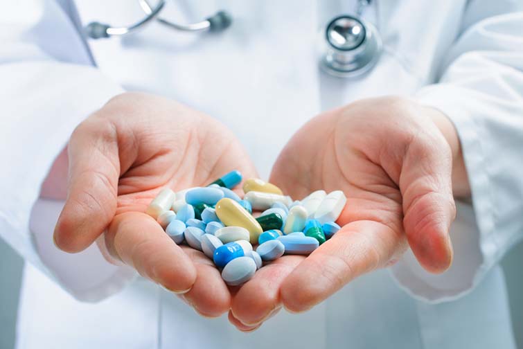 Hand of doctors holding many different pills