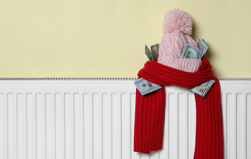 Knitted,Hat,And,Scarf,With,Money,On,Heating,Radiator,Near